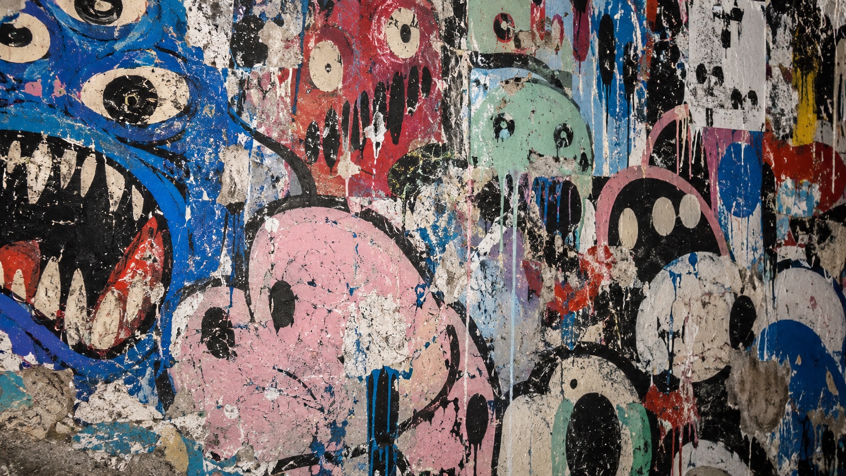 A wall of overlapping cartoon monsters and bubble letters in pink, blue and black.