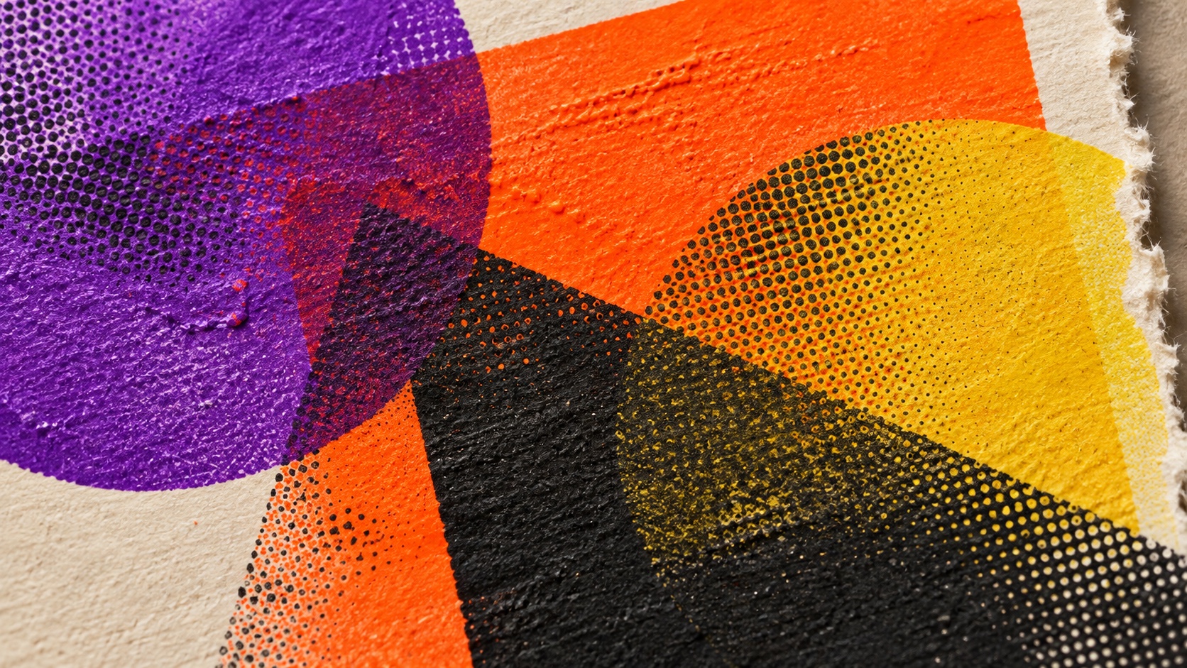 A close-up of thick violet, orange, yellow and black ink overprinting on deckled paper, with raised texture and halftone dots.
